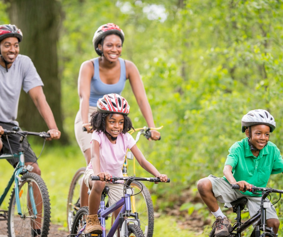 family biking and wearing helmets